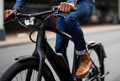 Zu sehen ist eine Nahaufname von einem Radfahrer, auf einem schwarzen Trek Bike.